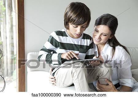 Mother and son using digital tablet together View Large Photo Image Stock Image - Mother and son using digital tablet together. Fotosearch