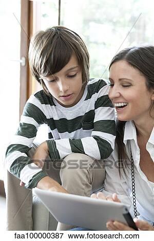 Mother and son using digital tablet together View Large Photo Image Stock Photo - Mother and son using digital tablet together. Fotosearch