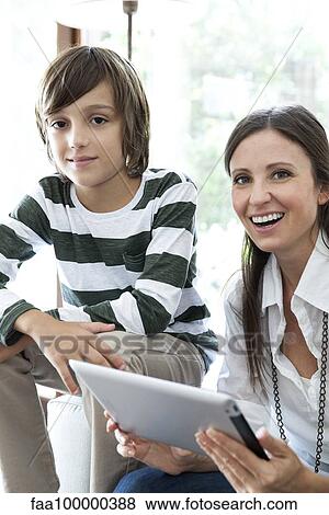 Mother and son using digital tablet together View Large Photo Image Stock Photo - Mother and son using digital tablet together. Fotosearch