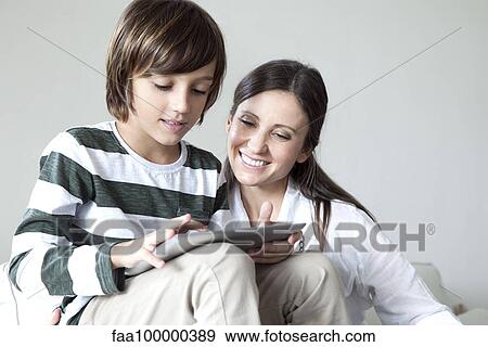 Mother and son using digital tablet together View Large Photo Image Stock Photo - Mother and son using digital tablet together. Fotosearch