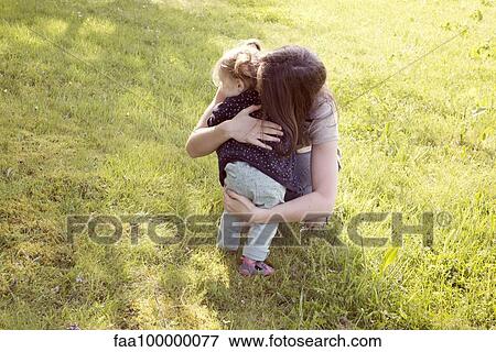 Mother embracing baby girl outdoors View Large Photo Image Stock Photo - Mother embracing baby girl outdoors. Fotosearch