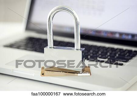 Padlock and credit card sitting on top of laptop computer View Large Photo Image Stock Photo - Padlock and credit card sitting on top of laptop computer. Fotosearch