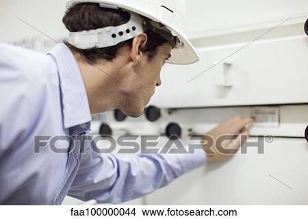 Technician operating industrial equipment View Large Photo Image Picture - Technician operating industrial equipment. Fotosearch