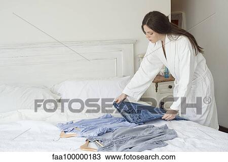 Woman choosing outfit to wear View Large Photo Image Stock Image - Woman choosing outfit to wear. Fotosearch