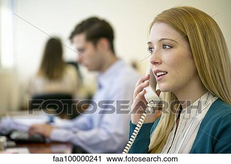 Woman using landline phone in office View Large Photo Image Stock Image - Woman using landline phone in office. Fotosearch