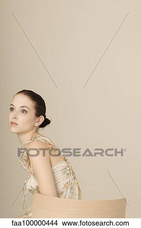 Woman wearing ruffly dress, hair in bun, portrait View Large Photo Image Picture - Woman wearing ruffly dress, hair in bun, portrait. Fotosearch