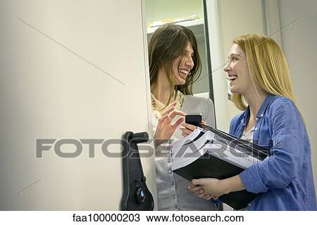 Women laughing together in office View Large Photo Image Stock Image - Women laughing together in office. Fotosearch