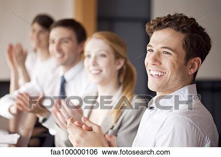 Young business professionals applauding during meeting View Large Photo Image Stock Photograph - Young business professionals applauding during meeting. Fotosearch