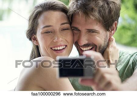 Young couple taking selfie with digital camera View Large Photo Image Stock Photograph - Young couple taking selfie with digital camera. Fotosearch