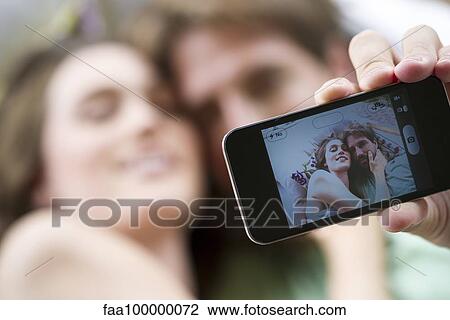Stock Image - Young couple taking selfie with smartphone. Fotosearch