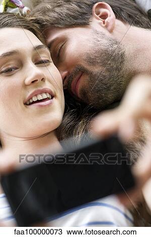 Stock Image - Young couple taking selfie with smartphone. Fotosearch