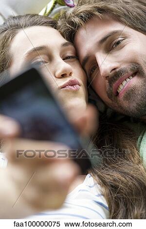 Young couple taking selfie with smartphone View Large Photo Image Stock Photography - Young couple taking selfie with smartphone. Fotosearch