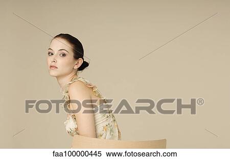 Young woman looking over shoulder at camera, portrait View Large Photo Image Stock Photography - Young woman looking over shoulder at camera, portrait. Fotosearch