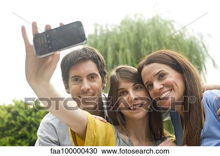 Young woman taking selfie with parents View Large Photo Image Stock Image - Young woman taking selfie with parents. Fotosearch