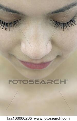 Stock Photography - Young woman with eyes closed, close-up. Fotosearch