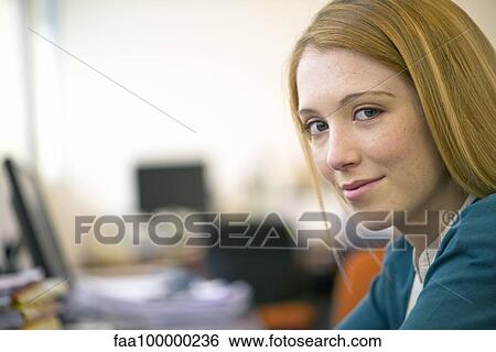 Stock Photograph - Young woman working in office, portrait. Fotosearch