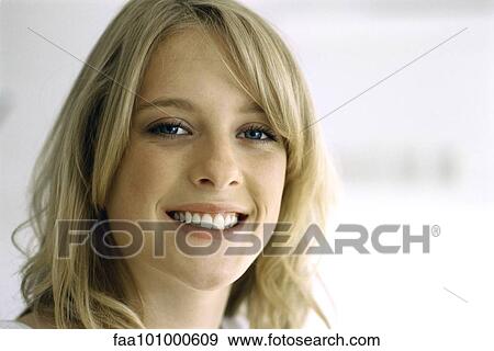 Stock Photo - "Blonde teenage girl smiling at camera, portrait". Fotosearch