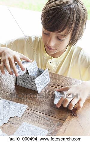 Boy building house of cards View Large Photo Image Picture - Boy building house of cards. Fotosearch