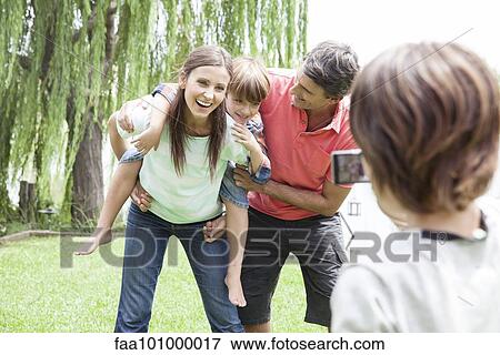 Boy taking snapshot of his family View Large Photo Image Stock Photo - Boy taking snapshot of his family. Fotosearch