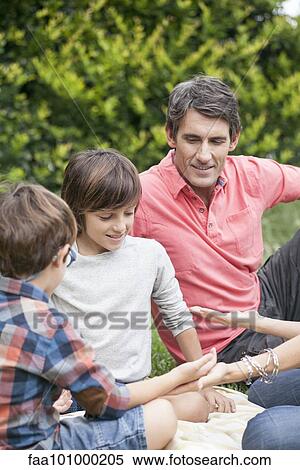 Boys playing hand game with family View Large Photo Image Stock Photography - Boys playing hand game with family. Fotosearch