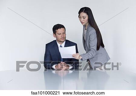 Business associates looking at document in meeting View Large Photo Image Stock Image - Business associates looking at document in meeting. Fotosearch