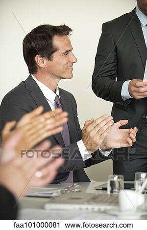 Stock Image - Businessman applauding at meeting. Fotosearch