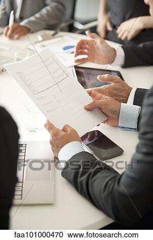Businessman at meeting reviewing document View Large Photo Image Stock Image - Businessman at meeting reviewing document. Fotosearch