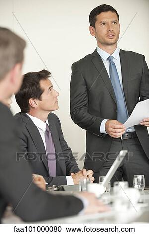 Stock Image - Businessman giving presentation at meeting. Fotosearch