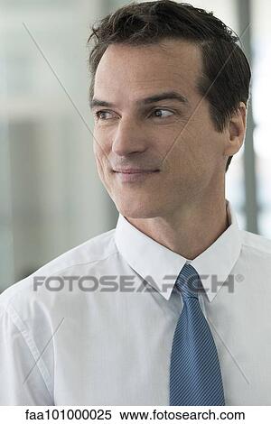 Stock Photography - "Businessman looking away in thought, smiling, portrait". Fotosearch