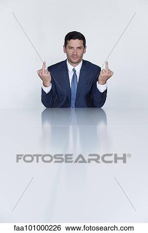 Stock Photograph - "Businessman making obscene gesture with both hands, portrait". Fotosearch