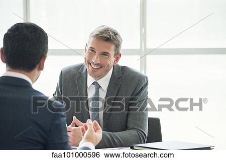 Businessman meeting with associate in office View Large Photo Image Stock Photograph - Businessman meeting with associate in office. Fotosearch