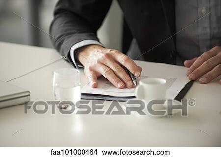 Picture - "Businessman reviewing document, cropped". Fotosearch