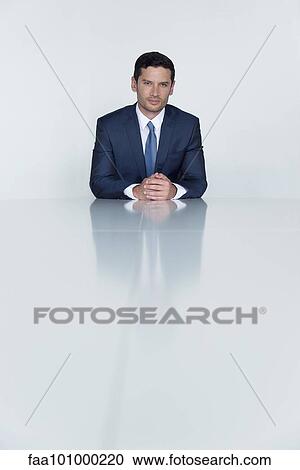 "Businessman seated at table, portrait" View Large Photo Image Stock Image - "Businessman seated at table, portrait". Fotosearch