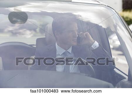 Businessman talking on cell phone in car View Large Photo Image Stock Image - Businessman talking on cell phone in car. Fotosearch