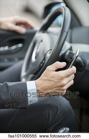 "Businessman text messaging while driving, cropped" View Large Photo Image Stock Photography - "Businessman text messaging while driving, cropped". Fotosearch