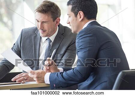 Businessmen discussing document in meeting View Large Photo Image Stock Image - Businessmen discussing document in meeting. Fotosearch