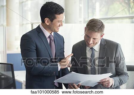 Businessmen discussing document together View Large Photo Image Stock Photography - Businessmen discussing document together. Fotosearch