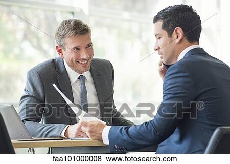 Businessmen discussing documents in meeting View Large Photo Image Stock Photo - Businessmen discussing documents in meeting. Fotosearch