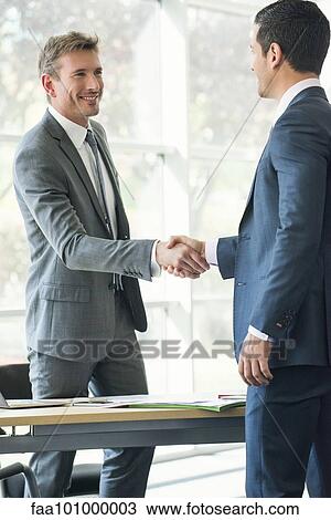 Businessmen shaking hands in office View Large Photo Image Stock Image - Businessmen shaking hands in office. Fotosearch