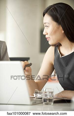 Stock Photo - Businesswoman collaborating with associate. Fotosearch