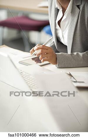 Stock Photograph - "Businesswoman taking notes at meeting, cropped". Fotosearch