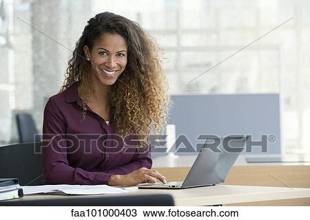 "Businesswoman using laptop computer in office, smiling, portrait" View Large Photo Image Stock Image - "Businesswoman using laptop computer in office, smiling, portrait". Fotosearch