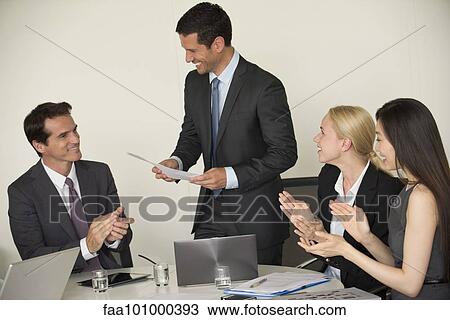 Executive receiving applause from colleagues during presentation View Large Photo Image Stock Image - Executive receiving applause from colleagues during presentation. Fotosearch
