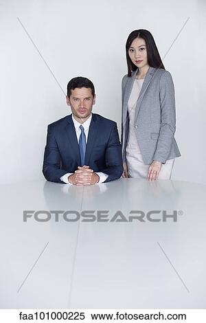 "Executive seated beside standing assistant, portrait" View Large Photo Image Stock Photography - "Executive seated beside standing assistant, portrait". Fotosearch