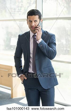 Executive talking on cell phone in office View Large Photo Image Stock Image - Executive talking on cell phone in office. Fotosearch