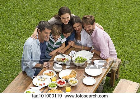 Stock Photo - Family and friends huddle for group picnic photo. Fotosearch