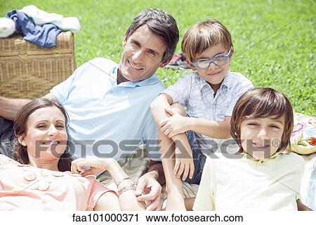Stock Image - Family relaxing together outdoors. Fotosearch