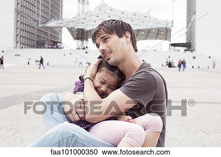 Father holding young daughter in his lap outdoors View Large Photo Image Stock Image - Father holding young daughter in his lap outdoors. Fotosearch