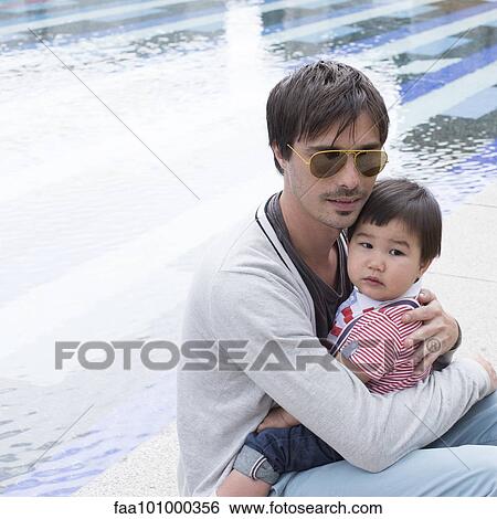 Father holding young son on lap outdoors View Large Photo Image Stock Photograph - Father holding young son on lap outdoors. Fotosearch