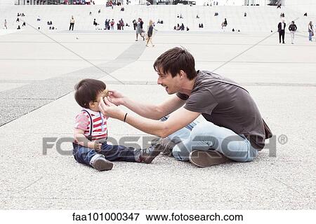 Father putting sunglasses on infant son outdoors View Large Photo Image Stock Photo - Father putting sunglasses on infant son outdoors. Fotosearch